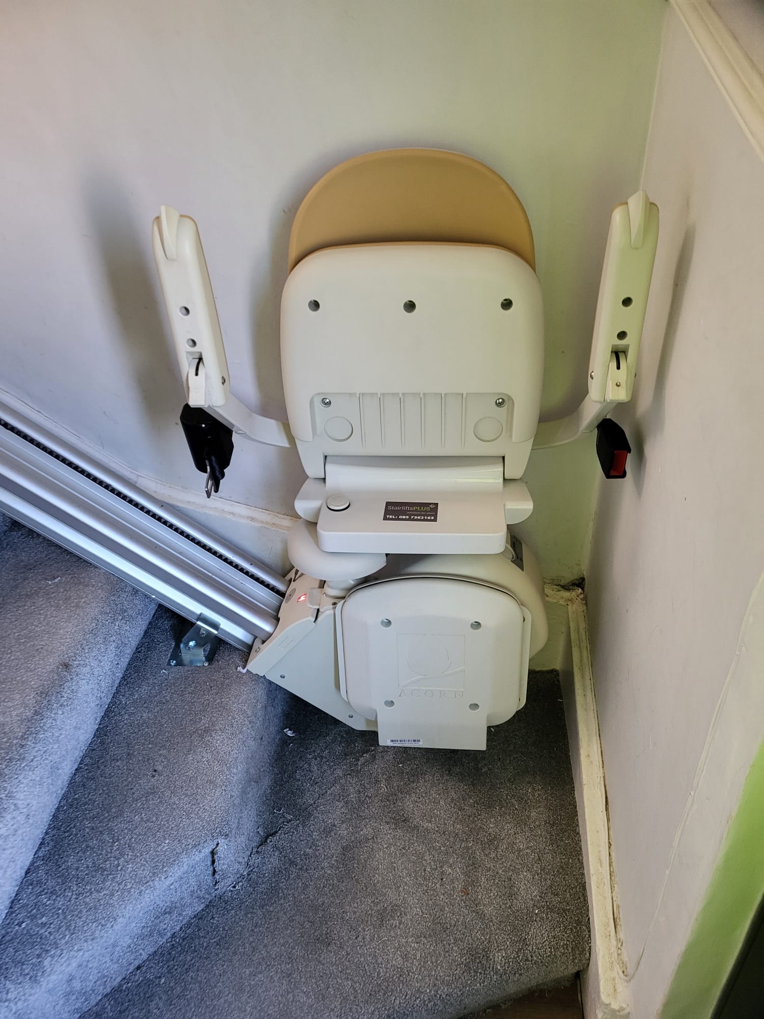 White and cream stairlift on a grey carpet
