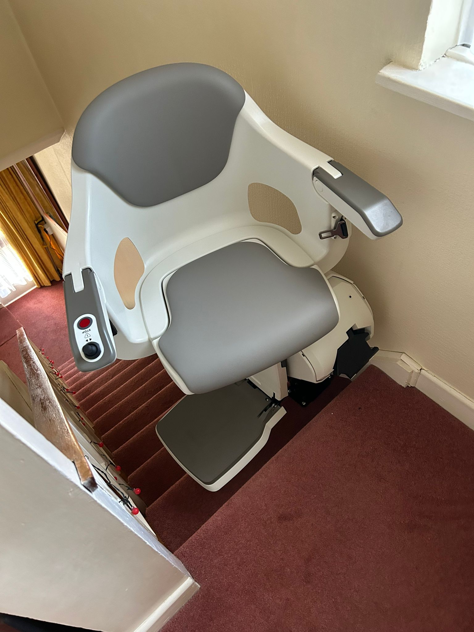 looking for stairlifts white and grey lift parked at the top of the stairs